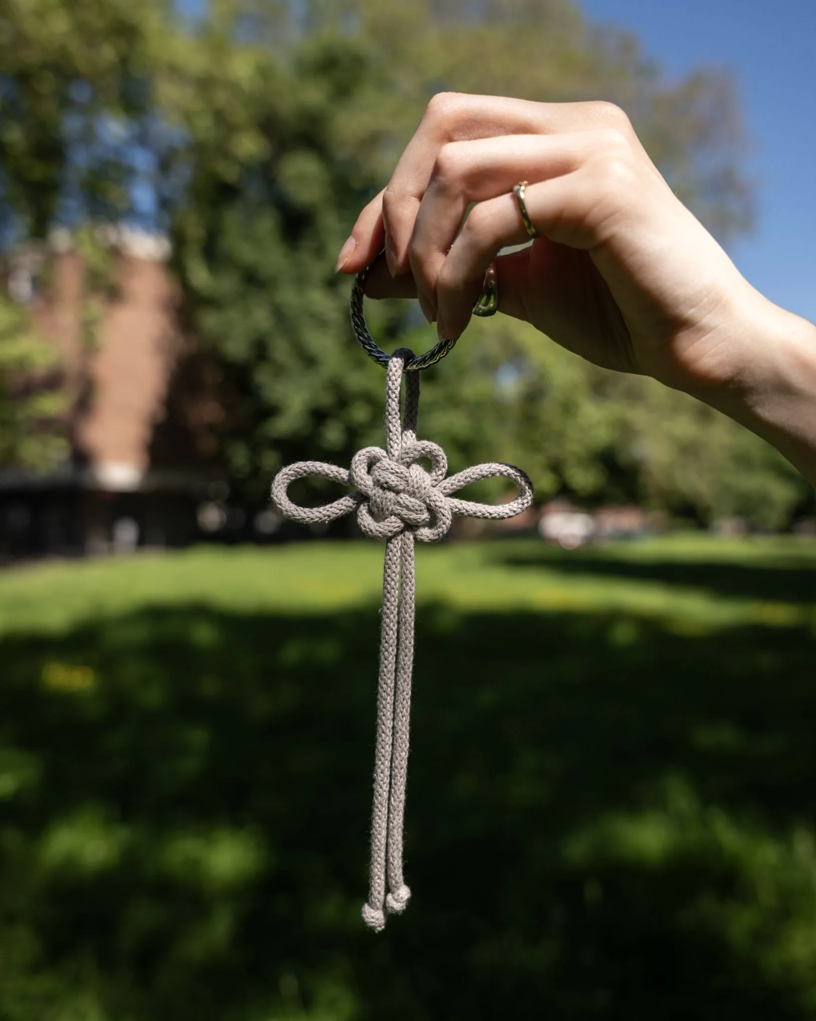 Grauer Glücksknoten-Anhänger mit modernem, schlichtem Design – handgemachtes Accessoire für Taschen und Schlüssel.
