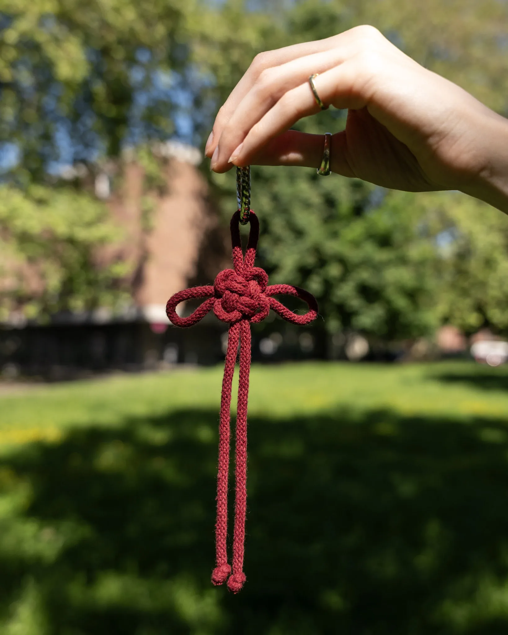 Roter Glücksknoten-Anhänger, handgefertigt und filigran geknotet – Symbol für Glück und positive Energie.